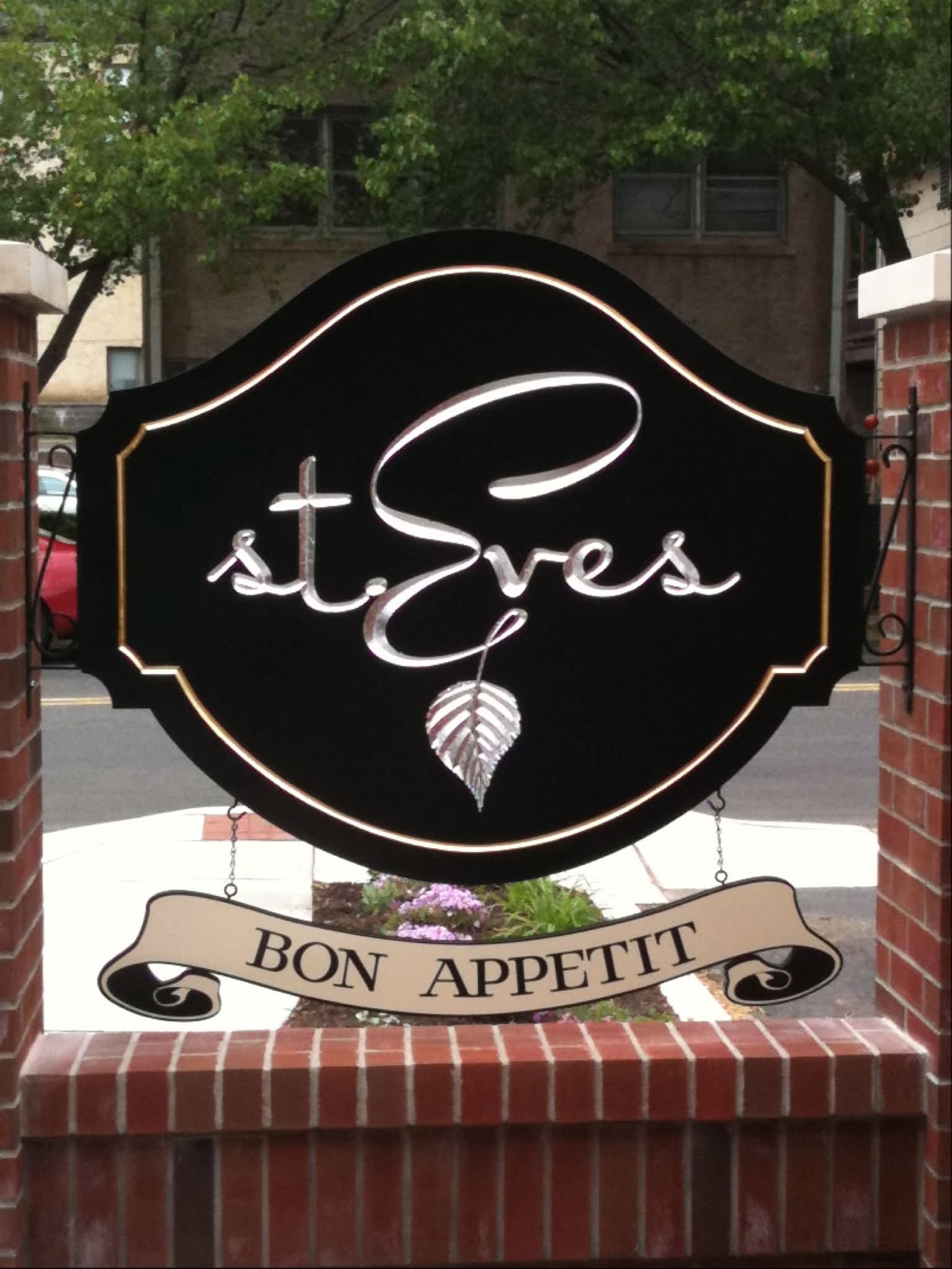 Hanging carved St. Eves restaurant sign with Bon Appetit banner